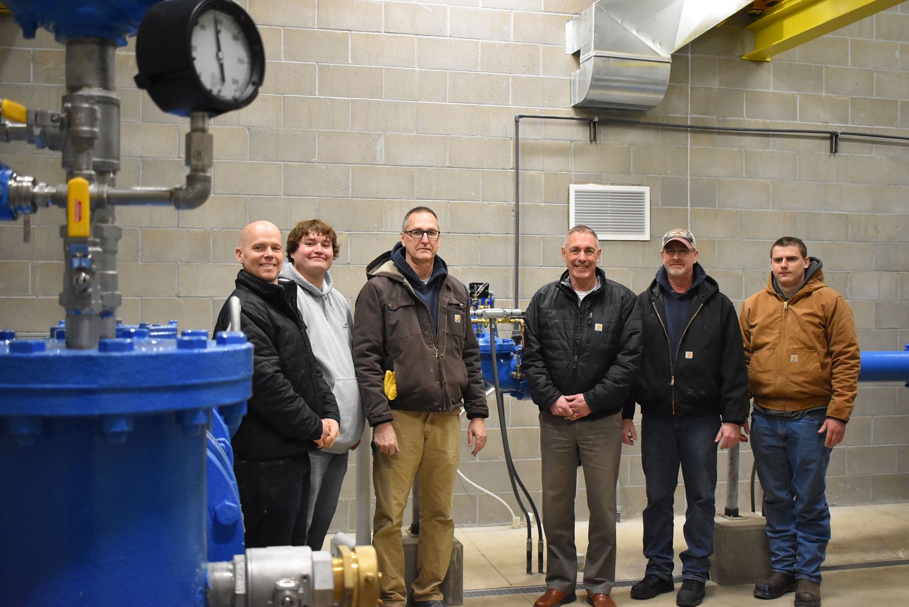 Men stand by large pipe